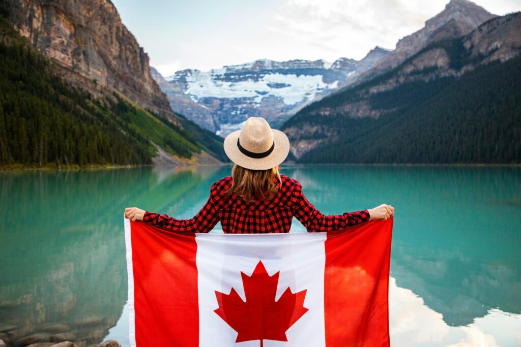 pexels-photo-2916828-2916828-1 Woman holding a Canadian flag at stunning Lake Louise, Alberta, embracing nature and patriotism.
